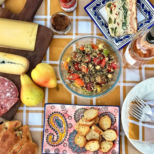 gourmet French picnic spread on tablecloth